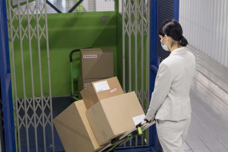 full shot woman carrying boxes